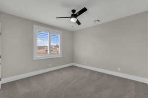 Spare room featuring carpet flooring and a ceiling fan