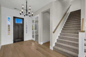 Entrance foyer featuring hanging lights and light wood finished floors