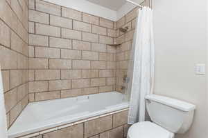 Bathroom featuring toilet and tiled tub/shower