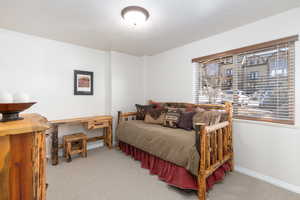 Bedroom with light colored carpet and baseboards