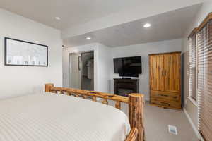 Bedroom featuring a closet, light colored carpet,  and recessed lighting
