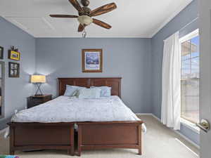 Carpeted bedroom featuring attic access and ceiling fan