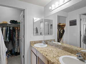 Full bath with a walk in closet and double vanity