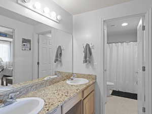 Ensuite bathroom featuring double vanity and light flooring