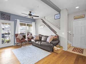 Living room featuring light wood-style floors, a ceiling fan, and recessed lighting