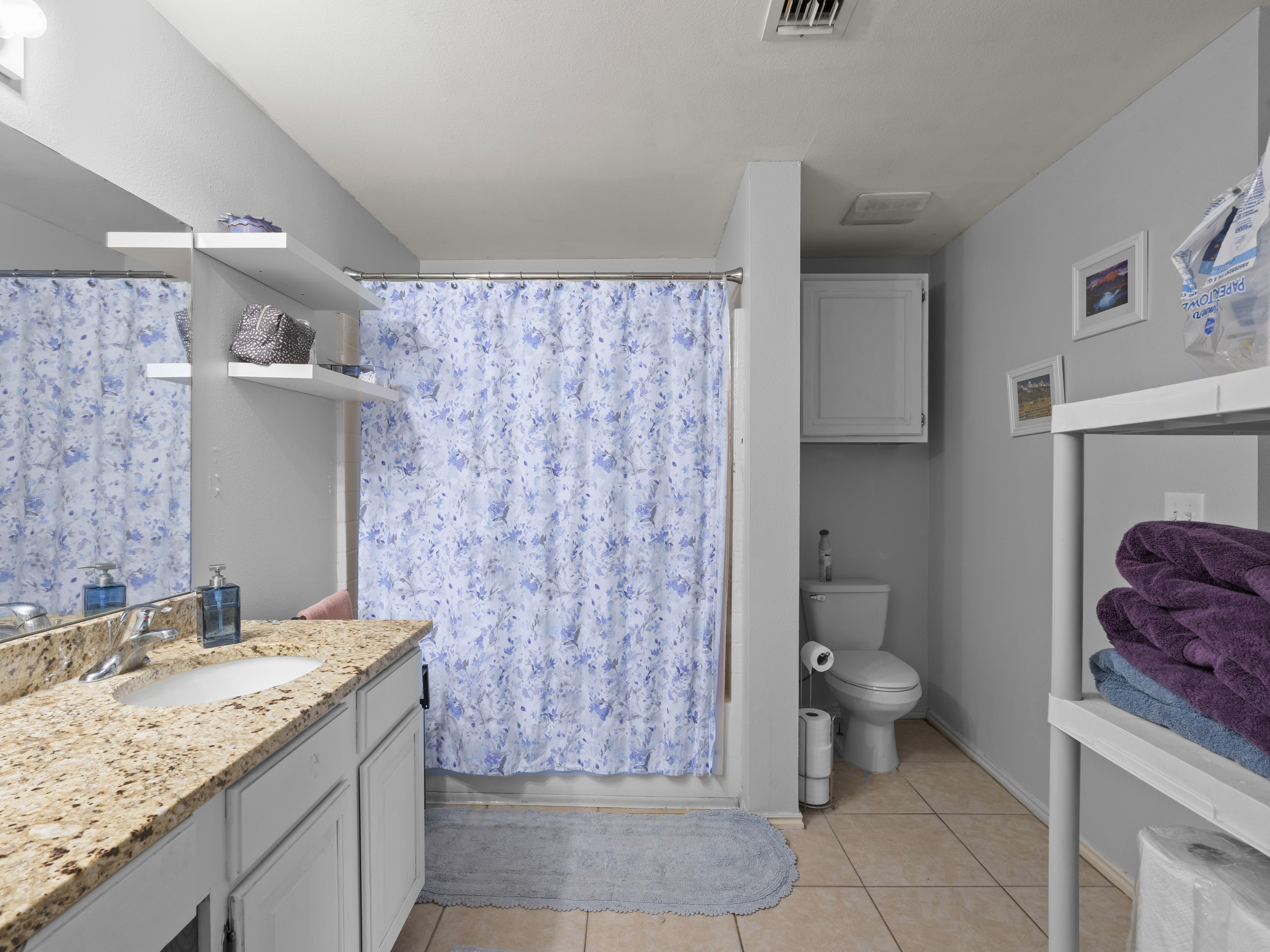 Bathroom featuring vanity, a shower with curtain, and light tile patterned floors