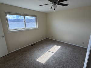 Empty room featuring light carpet and ceiling fan