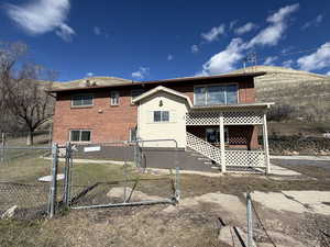 Rear view of property with a gate and brick siding