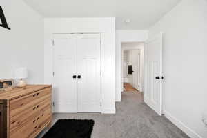 Bedroom with a closet and light colored carpet