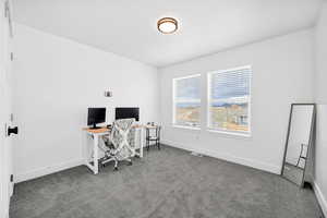 Office space with dark carpet and baseboards