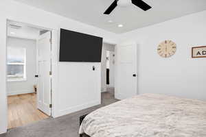 Bedroom with light colored carpet, a ceiling fan, and recessed lighting
