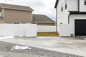 View of side of property with a shingled roof and driveway