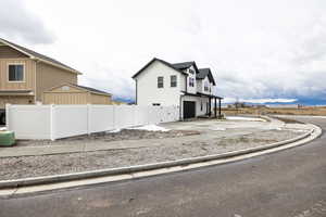 View of front facade with an attached garage, driveway, a mountain view, a residential view, and board and batten siding