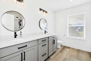 Full bathroom featuring double vanity, light wood-type flooring, a shower stall, and recessed lighting