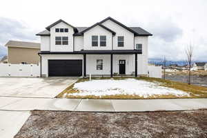 Modern farmhouse featuring a gate, board and batten siding, concrete driveway, a porch, and a garage
