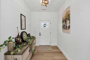Foyer featuring light wood-style flooring and baseboards