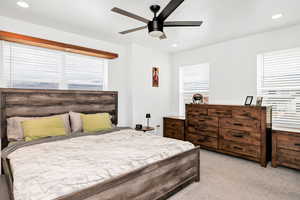 Bedroom featuring light carpet, multiple windows, ceiling fan, and recessed lighting
