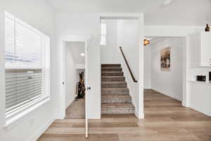 Stairs featuring healthy amount of natural light and wood finished floors