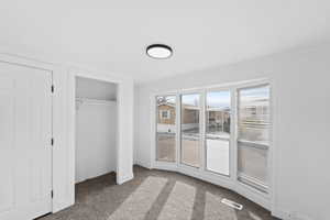 Unfurnished bedroom with light colored carpet and a closet