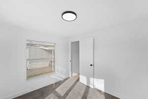 Unfurnished room with light colored carpet and baseboards