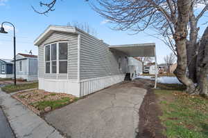 View of property exterior with asphalt driveway and an attached carport