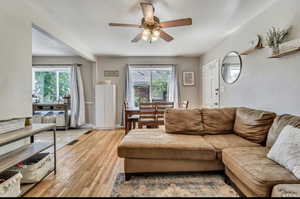 Living area featuring a ceiling fan, light wood finished floors, and plenty of natural light