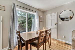 Dining area with baseboards and light wood-style flooring