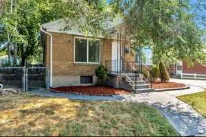 View of front facade with a gate and brick siding