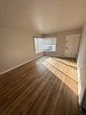 Unfurnished living room with hardwood / wood-style floors and baseboards