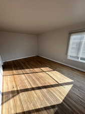 Unfurnished room with baseboards and hardwood / wood-style floors