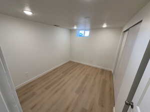 Basement featuring light wood-style flooring and baseboards