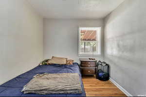 Bedroom featuring wood finished floors and a textured wall