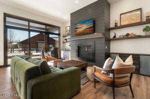 Living room with wood finished floors, a fireplace, and recessed lighting