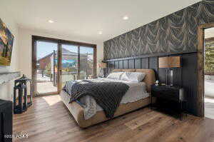 Bedroom featuring an accent wall, wallpapered walls, access to exterior, wood finished floors, and recessed lighting