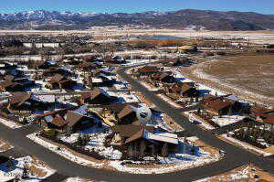 Snowy aerial view featuring a mountain view and a residential view