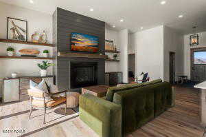 Living area with a glass covered fireplace, recessed lighting, and wood finished floors