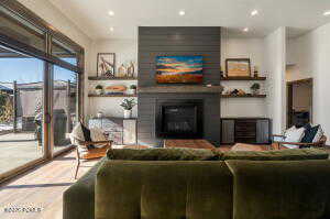 Living room featuring wood finished floors, a large fireplace, and recessed lighting