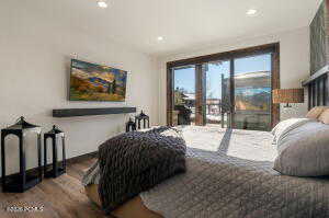 Bedroom featuring dark wood-style flooring, access to exterior, and recessed lighting