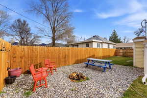 Fenced backyard featuring a fire pit