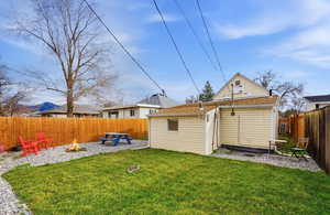 Rear view of house featuring a fire pit and a fenced backyard