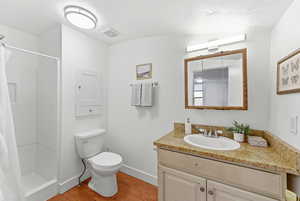 Full bath featuring vanity, a stall shower, and light wood-style flooring