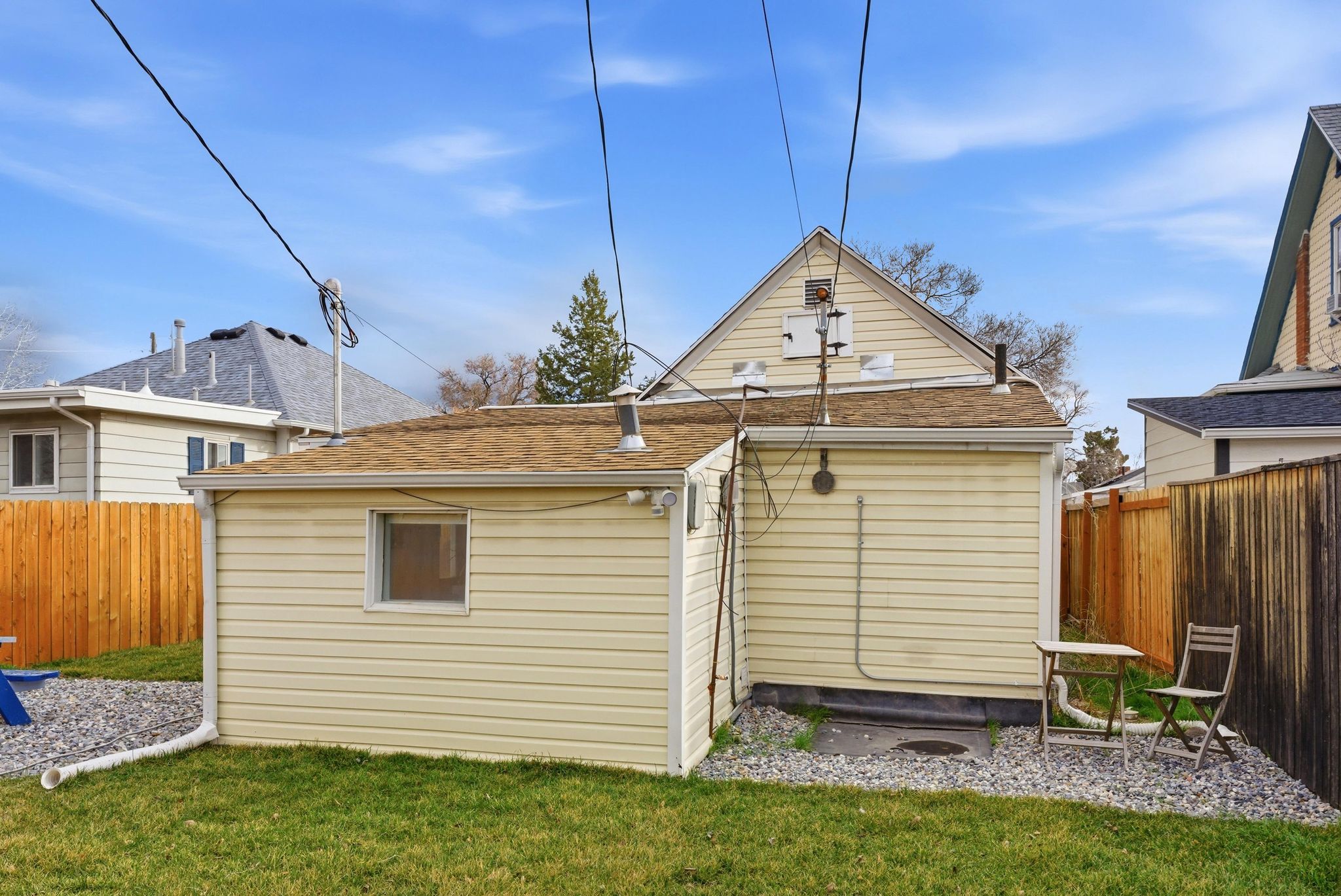 Rear view of house with a fenced backyard and roof with shingles