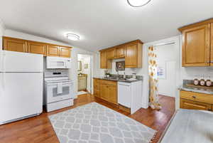 Kitchen featuring white appliances, light wood-style floors, and wood finish cabinetry