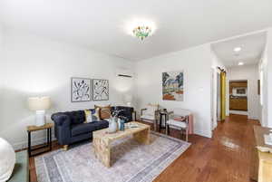 Living area with a barn door and wood-type flooring