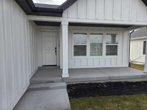 Property entrance featuring board and batten siding and covered porch