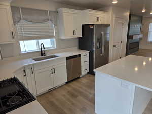 Kitchen featuring dark wood-style flooring, white cabinetry, stainless steel appliances, light stone countertops, and recessed lighting