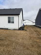 View of side of property featuring stucco siding and a shingled roof
