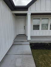 Doorway to property featuring board and batten siding and a porch