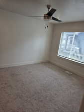 Empty room featuring carpet floors and ceiling fan