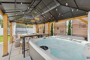 Fenced backyard featuring a trampoline, a patio area, and outdoor dining space